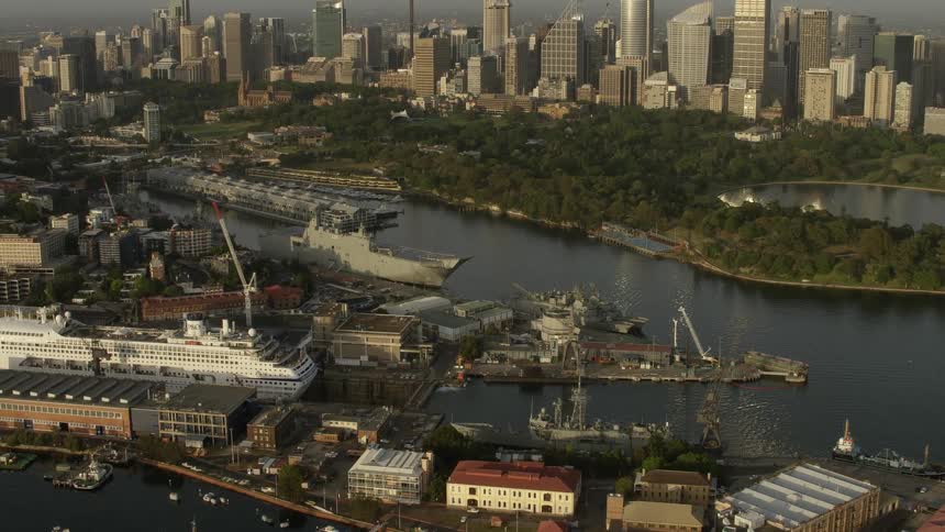 An aerial of a city among a waterway with large ships docked