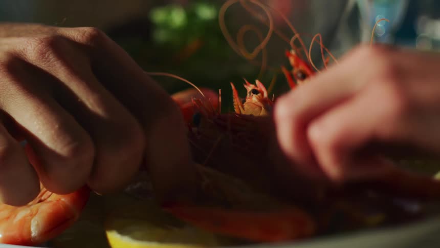 Lobster on a plate that two different hands reach for