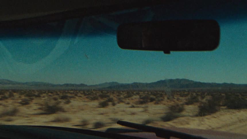 A moving car on a lonely deserted road evokes a sense of adventure freedom and isolation