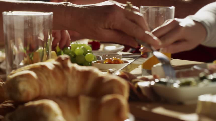 A group of people share a family style spread of fresh foods on a patio