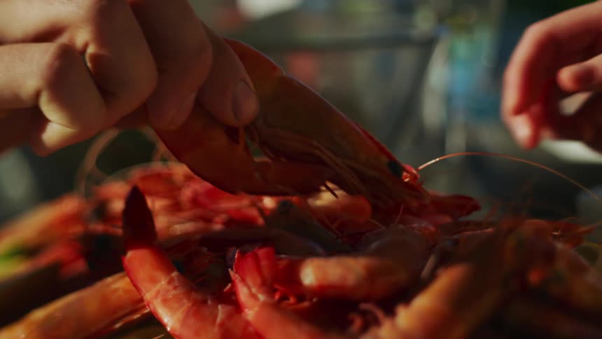A close up of two people grabbing crab legs off a plate