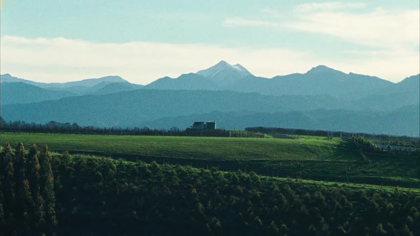 A landscape of green fields and mountains in the distance