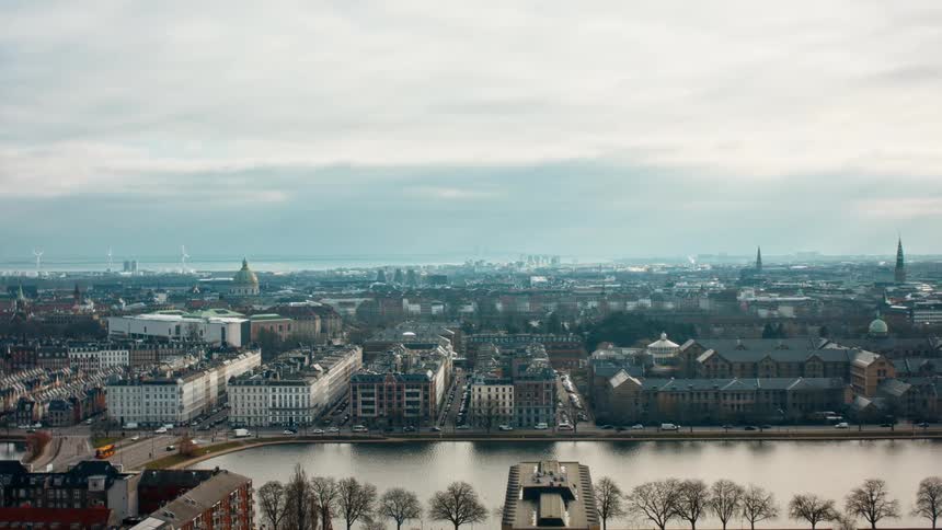 Aerial view of an urban city near a lake is displayed