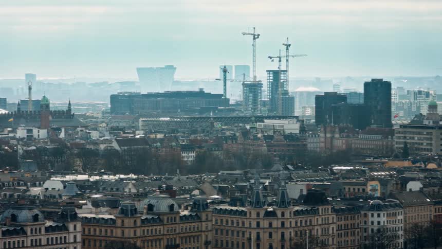 An aerial panning of a dense city with buildings on a waterfront