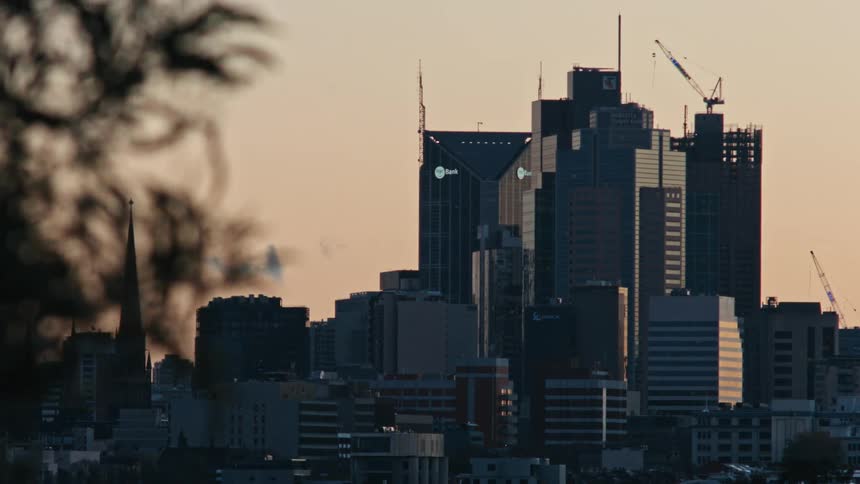 A towering structure that rises above the surrounding cityscape with other small building around it