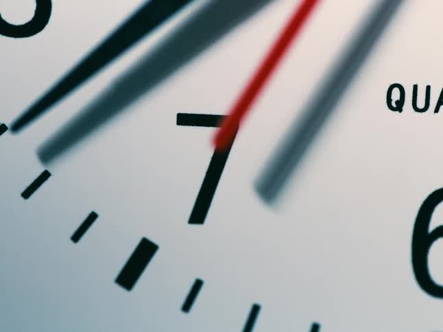 Close up of second hand moving across the seven on a clock