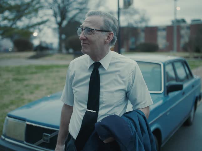 Older man arrives home from work with smile on his face