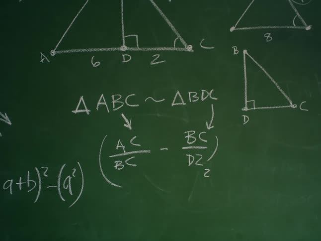 Formulas related to triangles are written on green chalkboard