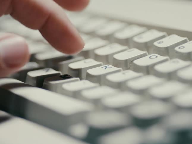 A persons fingers are typing on a keyboard