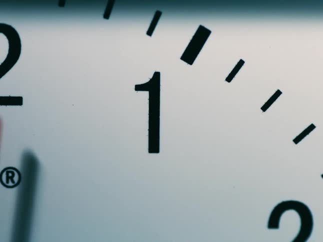 The red second hand of an analog clock moves by the number one