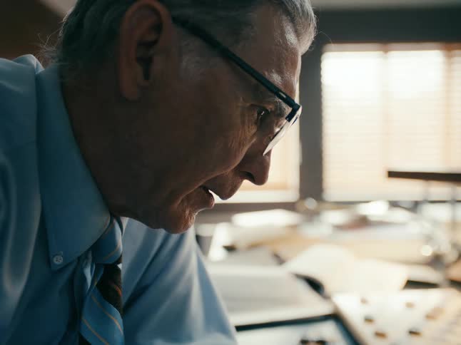An up close of a man wearing glasses working and thinking