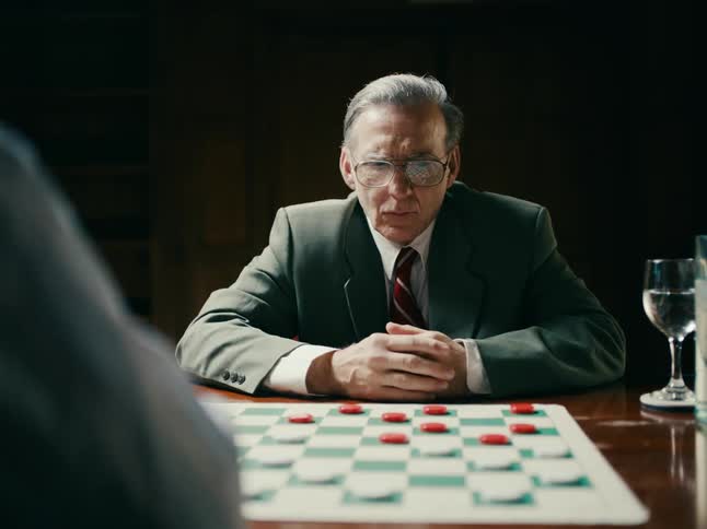 Older man makes move in checkers then hits time clock