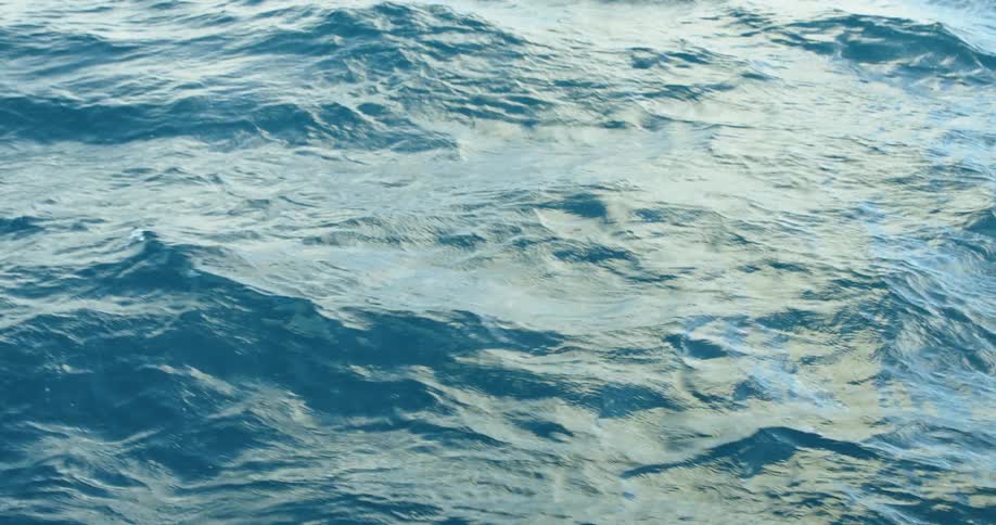 Sunlight reflects on water waves as they ripple and move