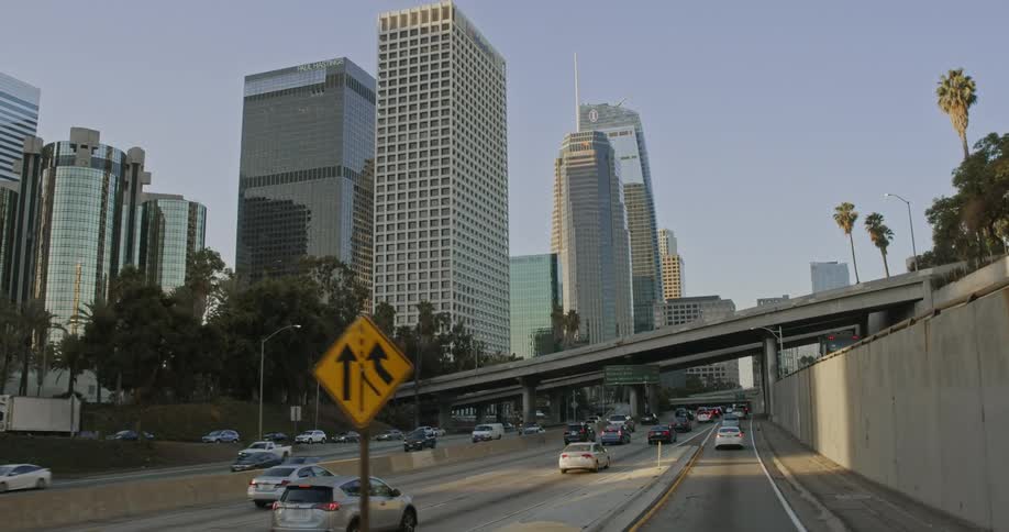 Traffic travels along a highway in a metropolis during the day