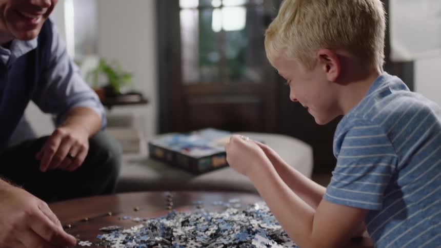 A father and son put a puzzle together