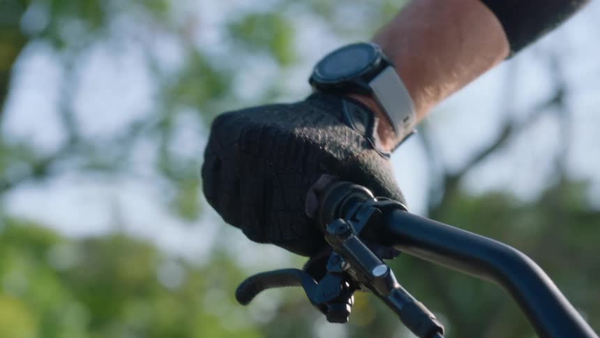 Male cyclist wears gloves while riding bicycle