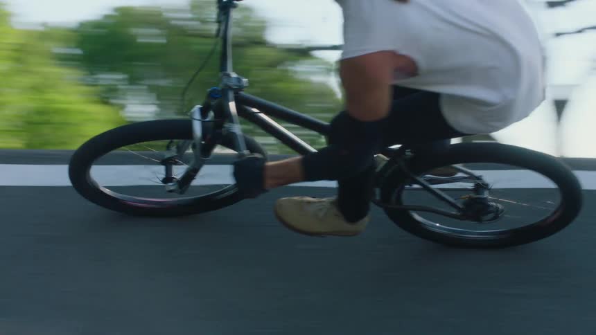 An up close of a person riding a bicycle around on a ramp