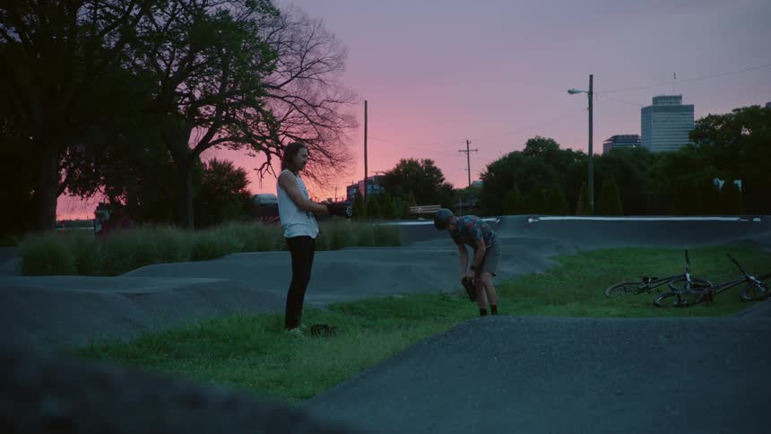 Father and son putting on gear gloves and socks to go cycling at sunset