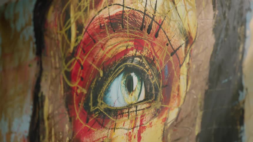 A blurry image then clearing up to show a painting of an eye