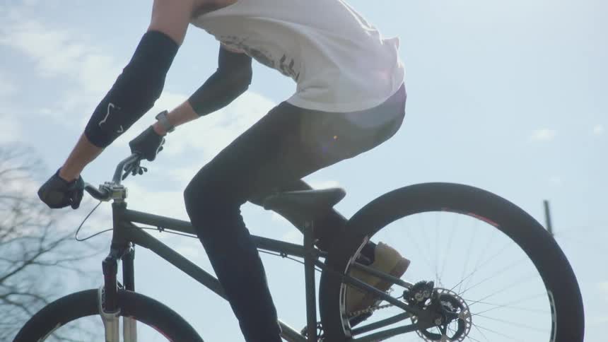 A man jumping his bicycle off a jump inpark
