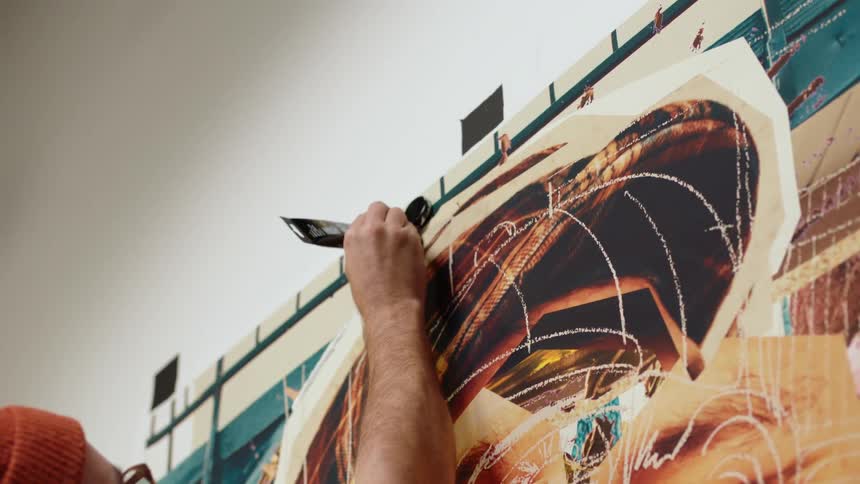 Close up of an artist painting on a large canvas with oils on the wall of a museum