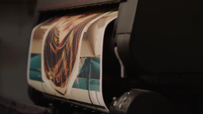 Close up of a large format printer printing a full color painting