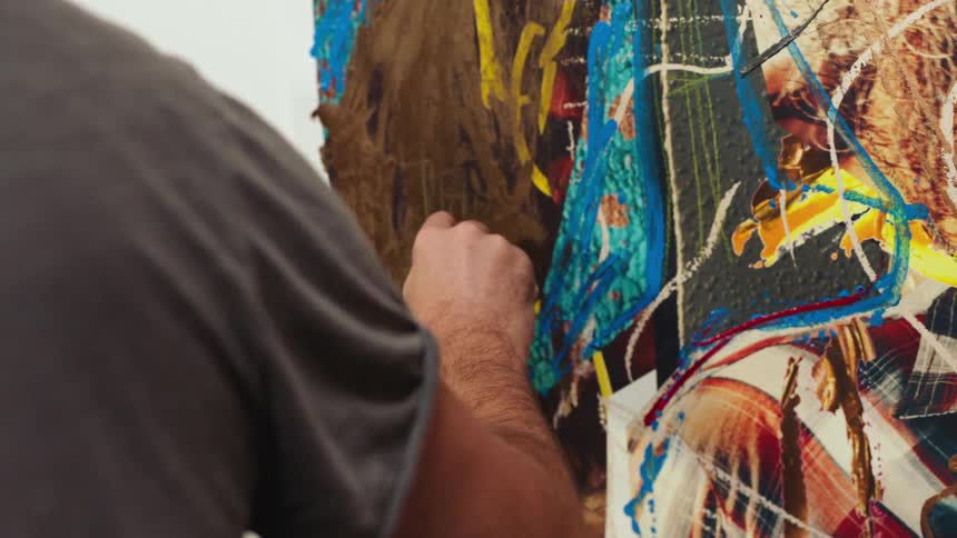 A man is painting on the canvas