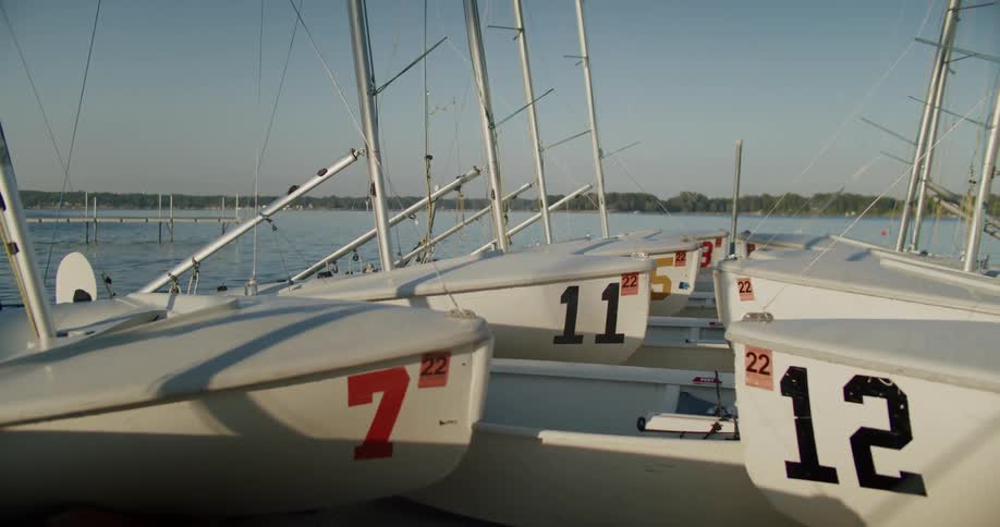 Multiple boats with large numbers on the side docked