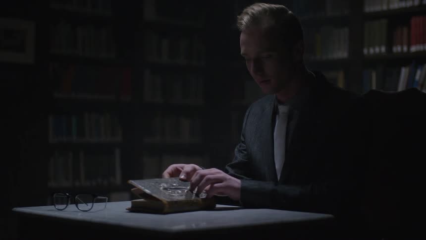 Man sits at a table with a book