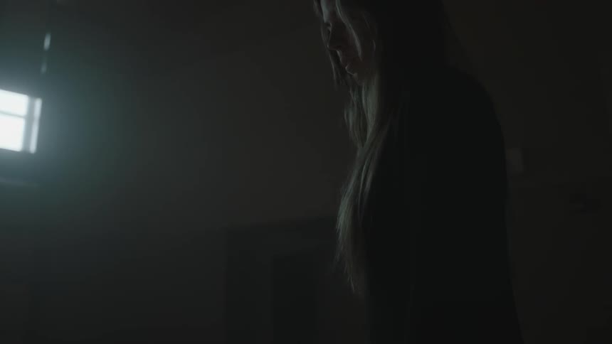 A woman is standing in a dark room