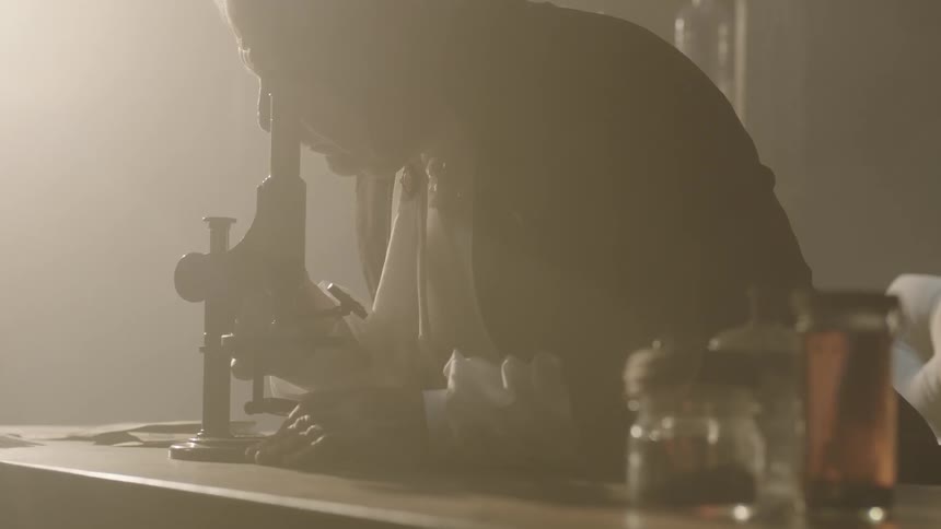 A man looks into a microscope