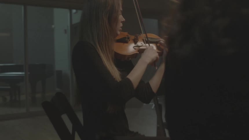 Chamber musicians sitting in a studio playing music