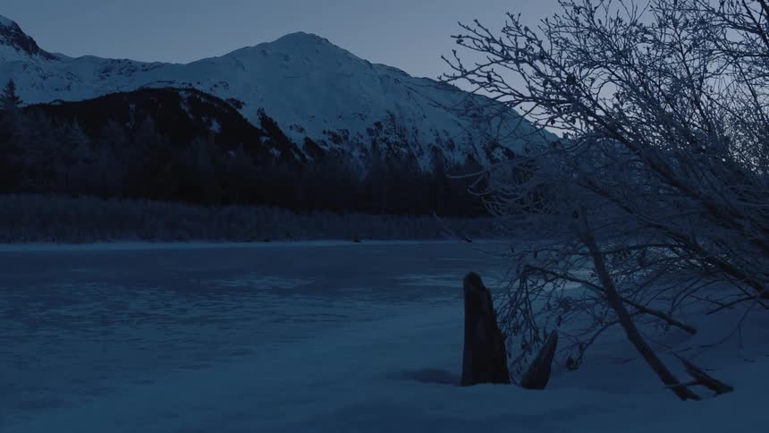 The sun is setting over the snow covered mountains