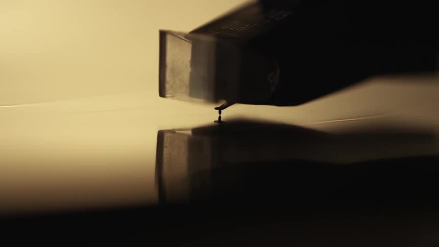 Close-up of a record player needle being placed on the record, music analog aesthetic