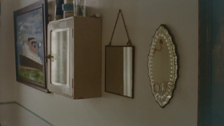Decorative mirrors and artwork hang on the wall of a home