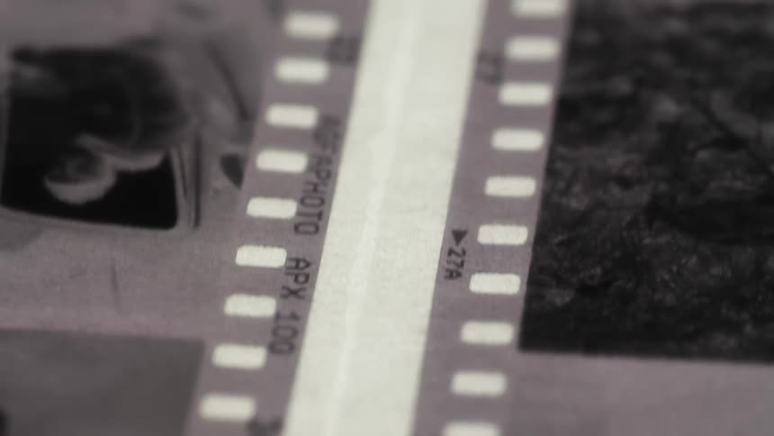 White strip lies across negatives on gray surface