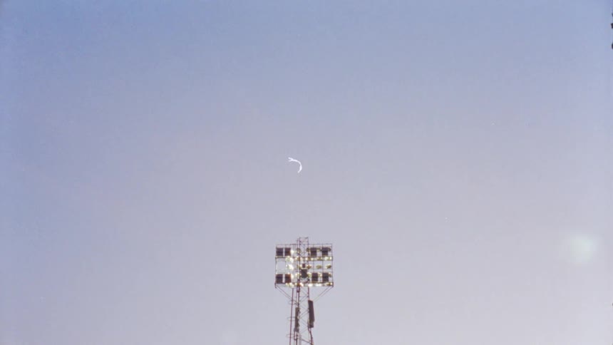 A stadium light against a gray sky - 16mm