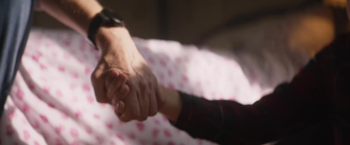 Grandfather grabs hand of sitting grandchild