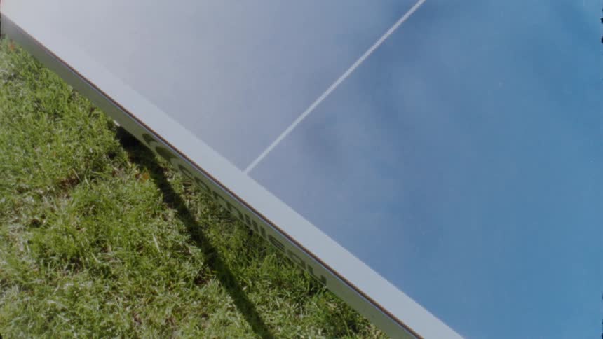 Shadows play over blue surface on panel on lawn