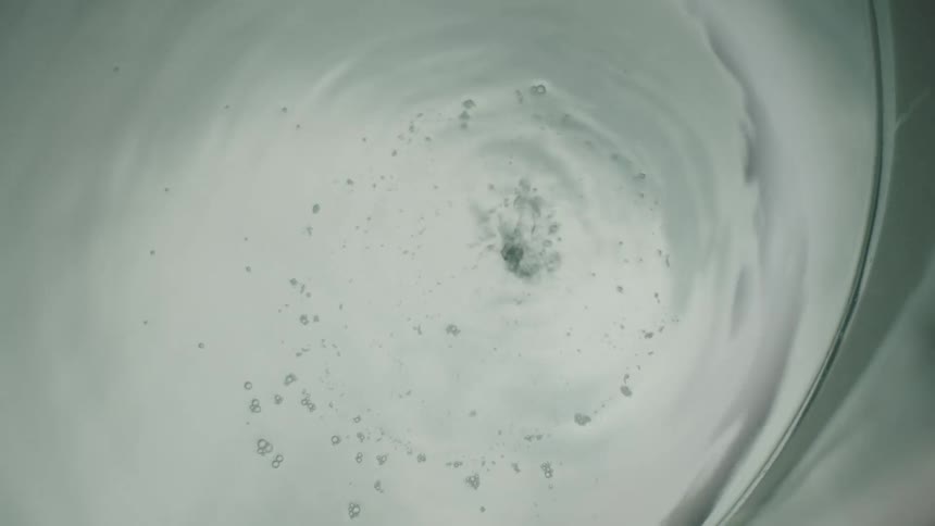 View of liquid being poured slowly into a bowl and the air bubbles it creates