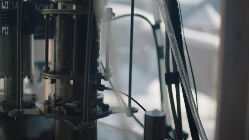 Liquid flows down clear tubing on machine near glass door