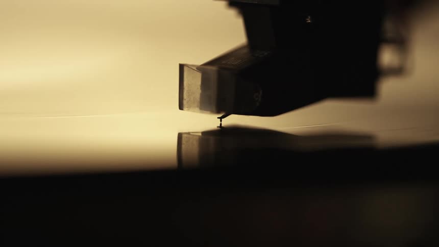 Close-up of a record player needle being placed on the record, music analog aesthetic