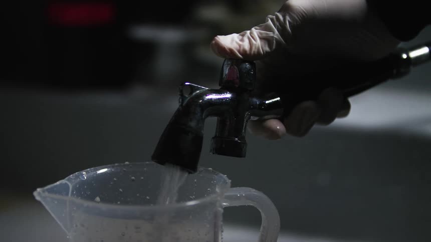 Pouring chemicals into developing tank, analog photography process with water