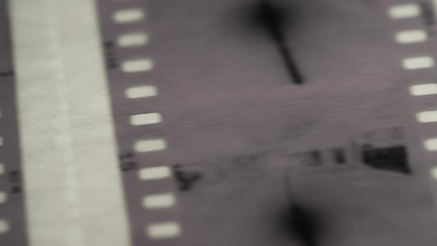 A black and white screen shows a row of film negatives