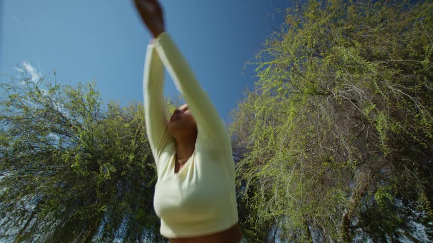 A woman is dancing outdoors during the spring