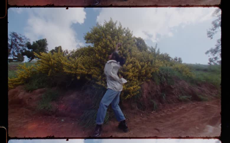 A young woman performs a modern dance outdoors