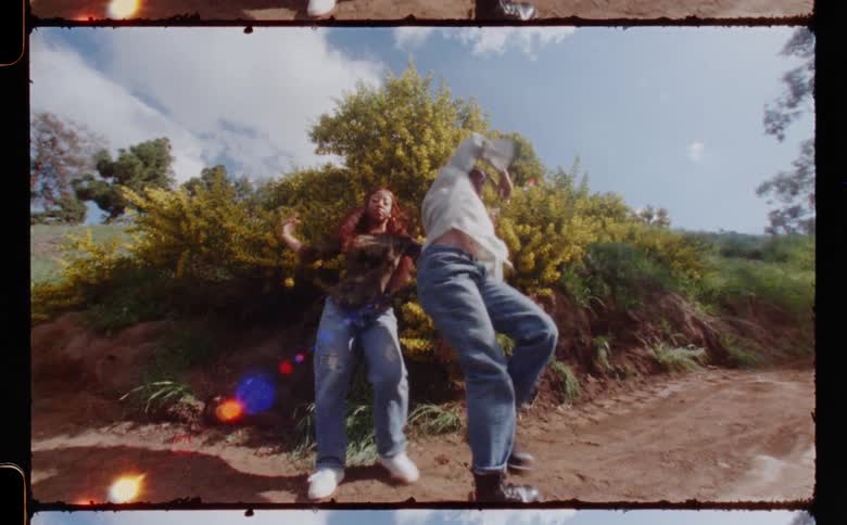Two young black women doing modern dance together on hiking trail in natural setting
