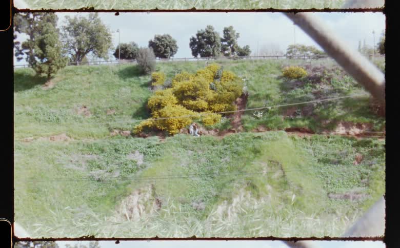 Two female dancers dance in center of slope and then walk away from each others