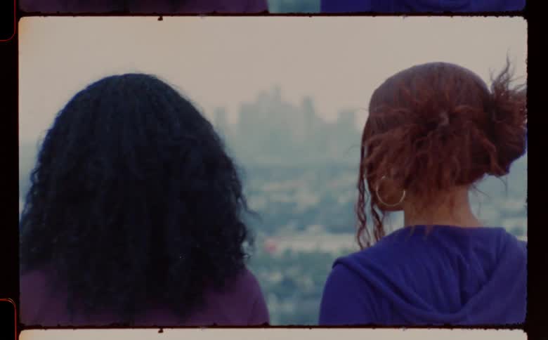 Two women face each other a distance from fog covered downtown then they turn their backs on each other and walk away
