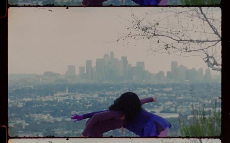 Two female dancers dance on foggy day with city skyline in the background